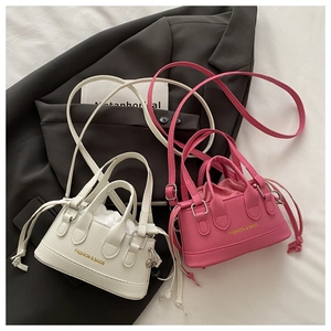 Detailed view of trendy drawstring handbags in ivory white and rose pink lychee leather
