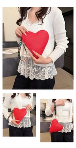 Detailansicht einer roten herzförmigen Clutch aus strukturiertem Leder mit LOVE-Band