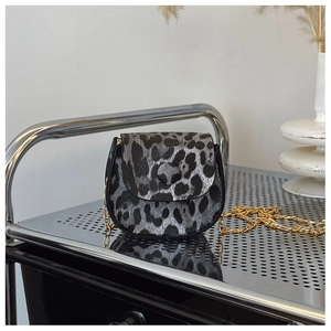 Detail of grey leopard print crossbody bag with gold chain strap and animal texture