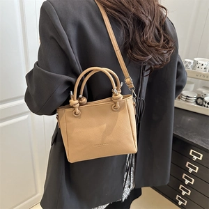 Minimalist camel lychee leather bucket bag for women, handheld and crossbody style