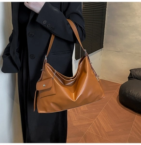 Close-up of caramel leather hobo tote bag featuring a small detachable coin purse accessory