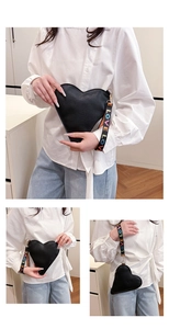 Detail der schwarzen herzförmigen Ledertasche mit buntem LOVE gewebtem Schultergurt