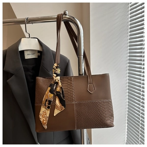 Détail du sac cabas patchwork serpent avec foulard en soie et fine bandoulière élégante