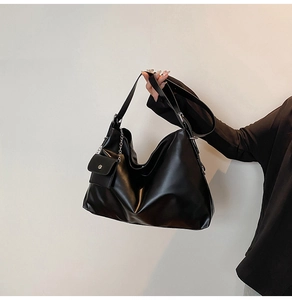 Detail of black PU leather tote bag featuring a metallic chain and detachable small pouch