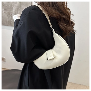 Detailed view of a white crescent moon bag featuring smooth faux leather and silver metal buckle