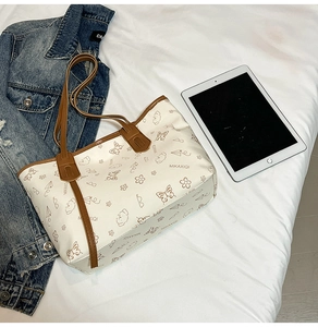 Detail of white tote bag with cartoon animal prints and brown leather shoulder straps