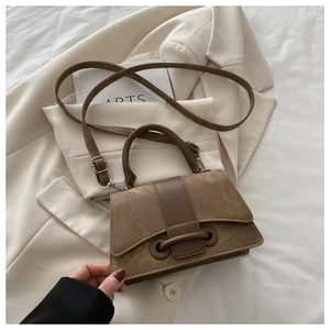 Detail of vintage brown textured crossbody bag with metal ring closure and thin strap