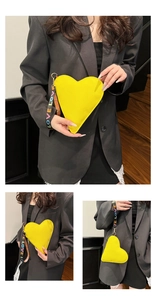 Detail der gelben herzförmigen Clutch mit Litschitextur und LOVE-Handschlaufe