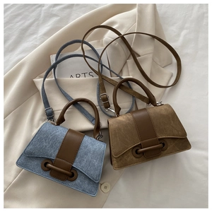 Detail of vintage denim and leather mini crossbody bags in blue and tan colors