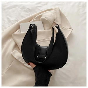 Close-up of black matte leather hobo bag with silver buckle and minimalist wide strap