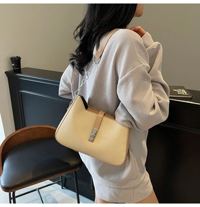 Detail showing beige woven texture bag with leather strap and silver twist lock