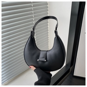 Detail of black crescent shoulder bag featuring smooth leather and silver metal buckle