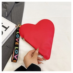Detail der roten Herz-Tasche aus Leder mit Narbung und LOVE-Schriftzug am Griff