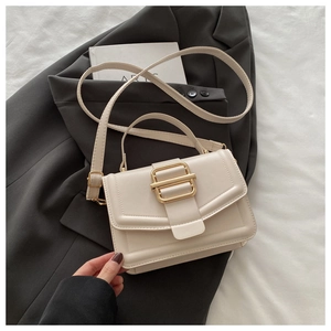 Détail d'un sac à main beige en cuir PU avec une grande boucle carrée dorée élégante