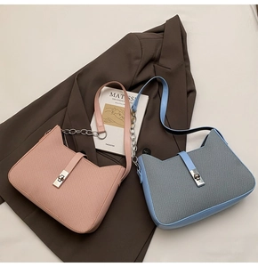 Detail of pink and light blue woven texture underarm bags with metallic turn-lock closure
