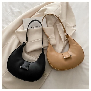 Close-up of minimalist crescent shoulder bags in black and khaki with metal buckles