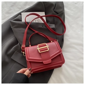 Détail du sac à main en cuir bordeaux avec boucle dorée et bandoulière réglable sur mesure