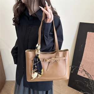 Brown faux leather tote bag with white stitching and printed silk scarf on handle