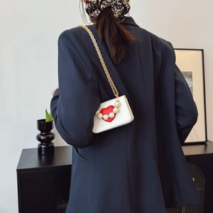 Mini sac bandoulière blanc avec cœur rouge, perles et chaîne dorée sur blazer