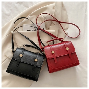 Dettaglio di borse a tracolla vintage quadrate in nero e rosso scuro con oro