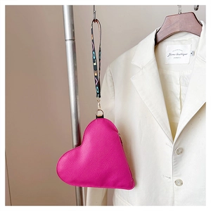 Detail der fuchsia-herzförmigen Geldbörse mit Litschi-Lederstruktur und LOVE-Band