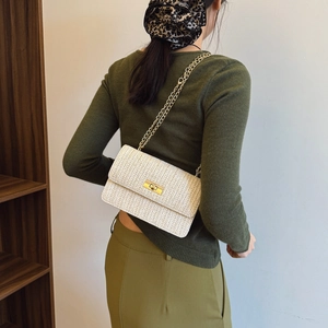 Straw woven chain crossbody bag with gold lock and cream-white V-shaped pattern
