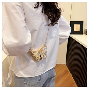 Detailed back view of a golden butterfly crossbody bag with crystals on a white shirt
