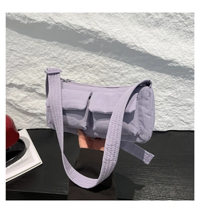 Dettaglio della borsa a tracolla in nylon viola chiaro con doppie tasche frontali utili