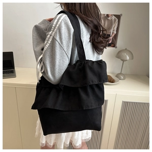 Detail shot of black ruffle canvas tote bag featuring stylish layered pleats and large capacity