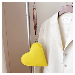 Detail einer gelben herzförmigen Ledertasche mit LOVE-Band und goldenem Clipverschluss