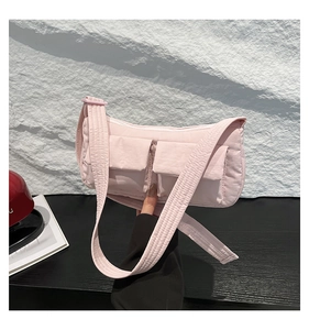 Dettaglio borsa a tracolla trapuntata rosa in nylon con due tasche frontali e tracolla larga