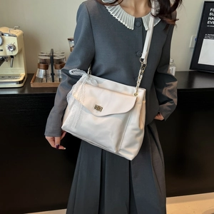 Schicke beige Spitzen-Tasche mit goldenem Drehverschluss und eleganter Schleife