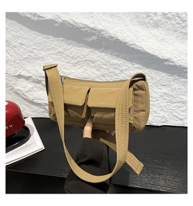 Dettaglio della borsa a tracolla in nylon kaki con doppie tasche e cinturino