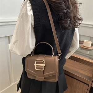 Sac bandoulière en cuir marron avec poignée et boucle dorée en décor quotidien