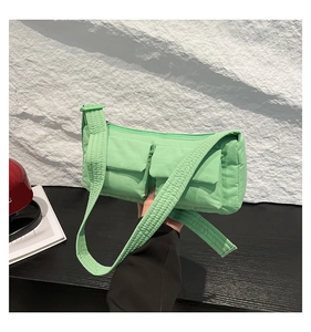 Vista frontale della borsa a tracolla in nylon trapuntato verde menta con due tasche