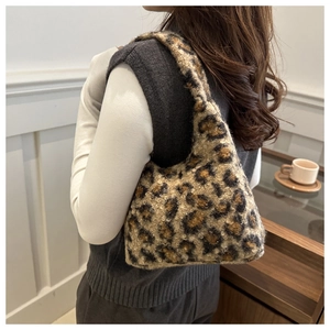 Sac à bandoulière tendance en fausse fourrure léopard porté dans un décor chaleureux