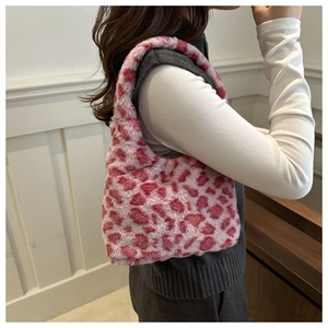 Détail du sac bandoulière en peluche léopard rose et blanc en fausse fourrure douce sur l'épaule