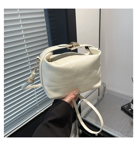 Detail of cream white leather handbag with block design and metallic buckle closure
