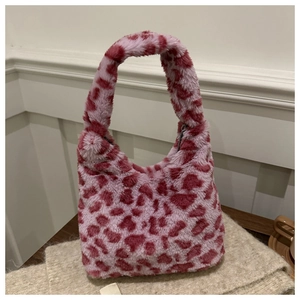 Gros plan sur le sac à main en peluche léopard rose et rouge avec texture en fausse fourrure