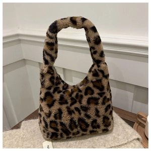 Gros plan d'un sac à main léopard en fausse fourrure sur un tricot doux et élégant