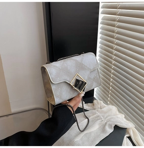 Détail du sac bandoulière argenté à matelassage géométrique et boucle carrée dorée