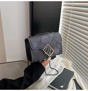 Détail du petit sac carré en denim gris foncé avec fermoir doré et bandoulière chaîne