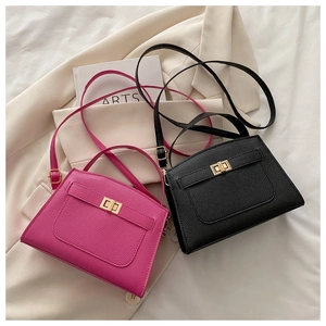 Detail of lychee textured leather bags in black and rose red with gold buckle lock