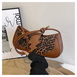 Vue détaillée du rabat en forme d'éclair et de l'imprimé léopard sur le sac cuir