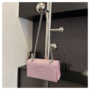 Close-up of pink glitter evening bag with silver metal handle and luxury sequin texture