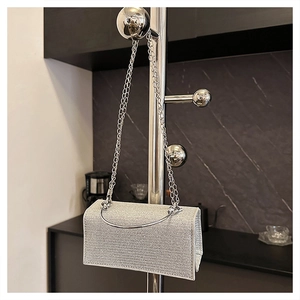 Close-up of sparkling silver glitter evening bag with metal chain and top handle