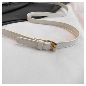 Detail view of a white PU leather shoulder strap with gold buckle and precise stitching