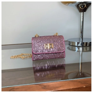 Détail du sac bandoulière à paillettes roses avec finition cristal et fermoir rotatif