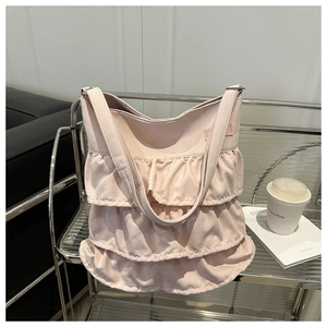 Detailed view of pink ruffled nylon fabric with triple-layered pleated design on a tote bag