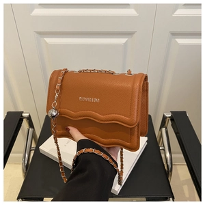 Detail of brown litchi pattern leather bag with wave-cut flap and silver chain strap